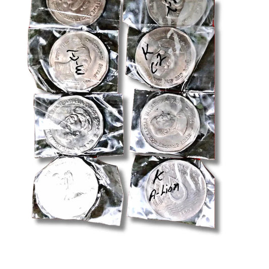 Packaged collectible Indian commemorative coins with historical figures and handwritten labels