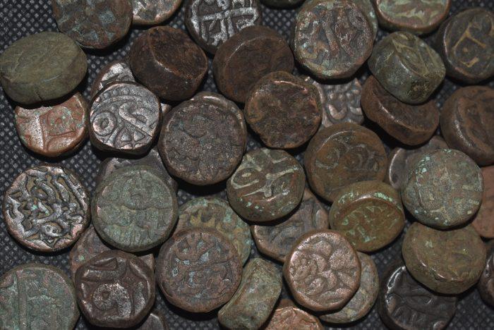 Rare antique Indian coins with intricate designs, collectible old currency on display